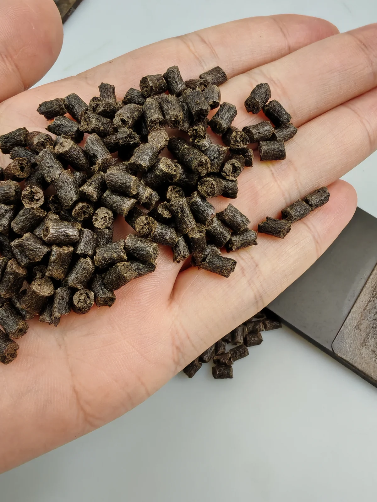 Coffee fiber PP masterbatch pellets held in hand