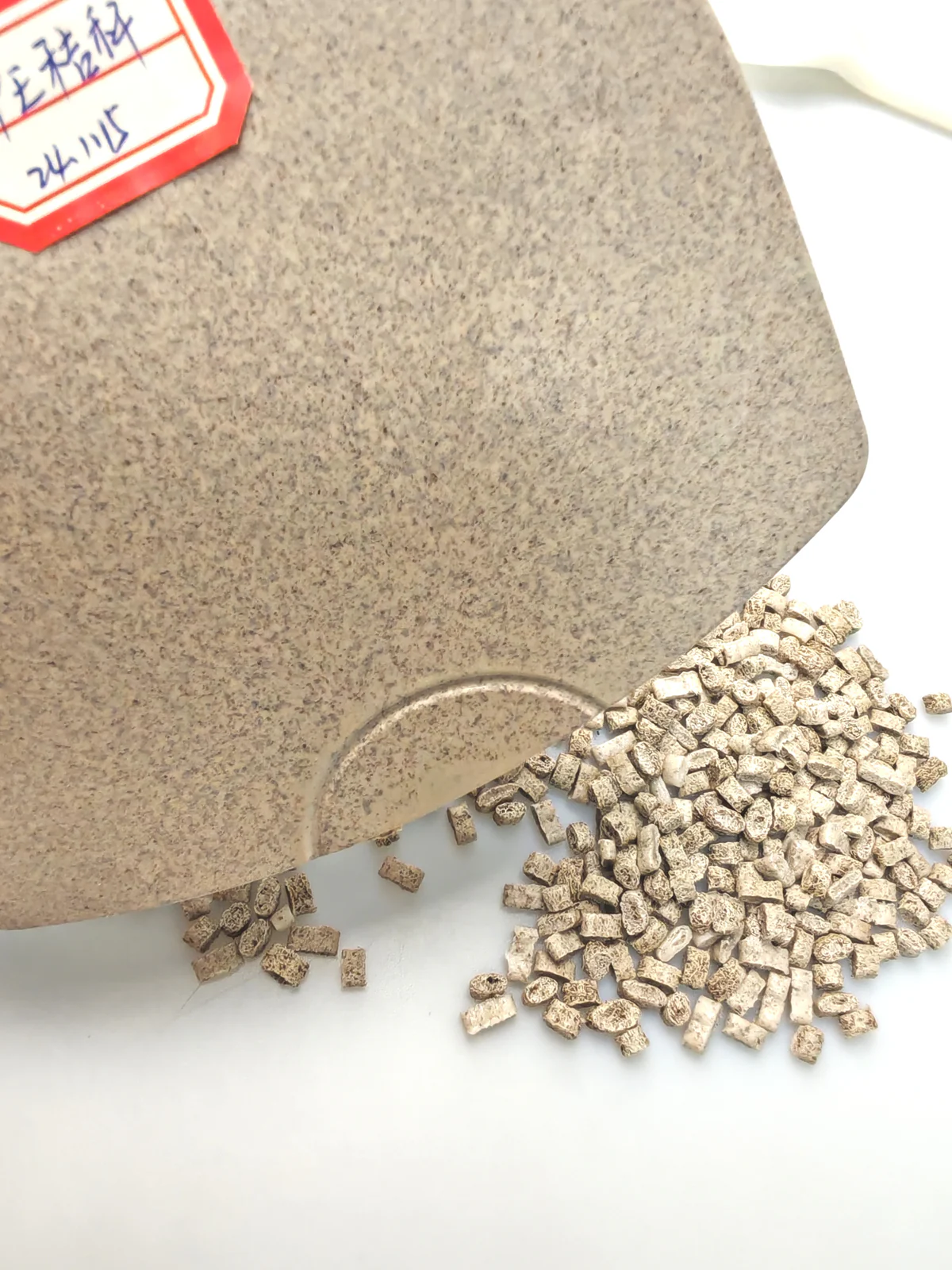 Close view of a wheat straw fiber PE sample plaque and pellets