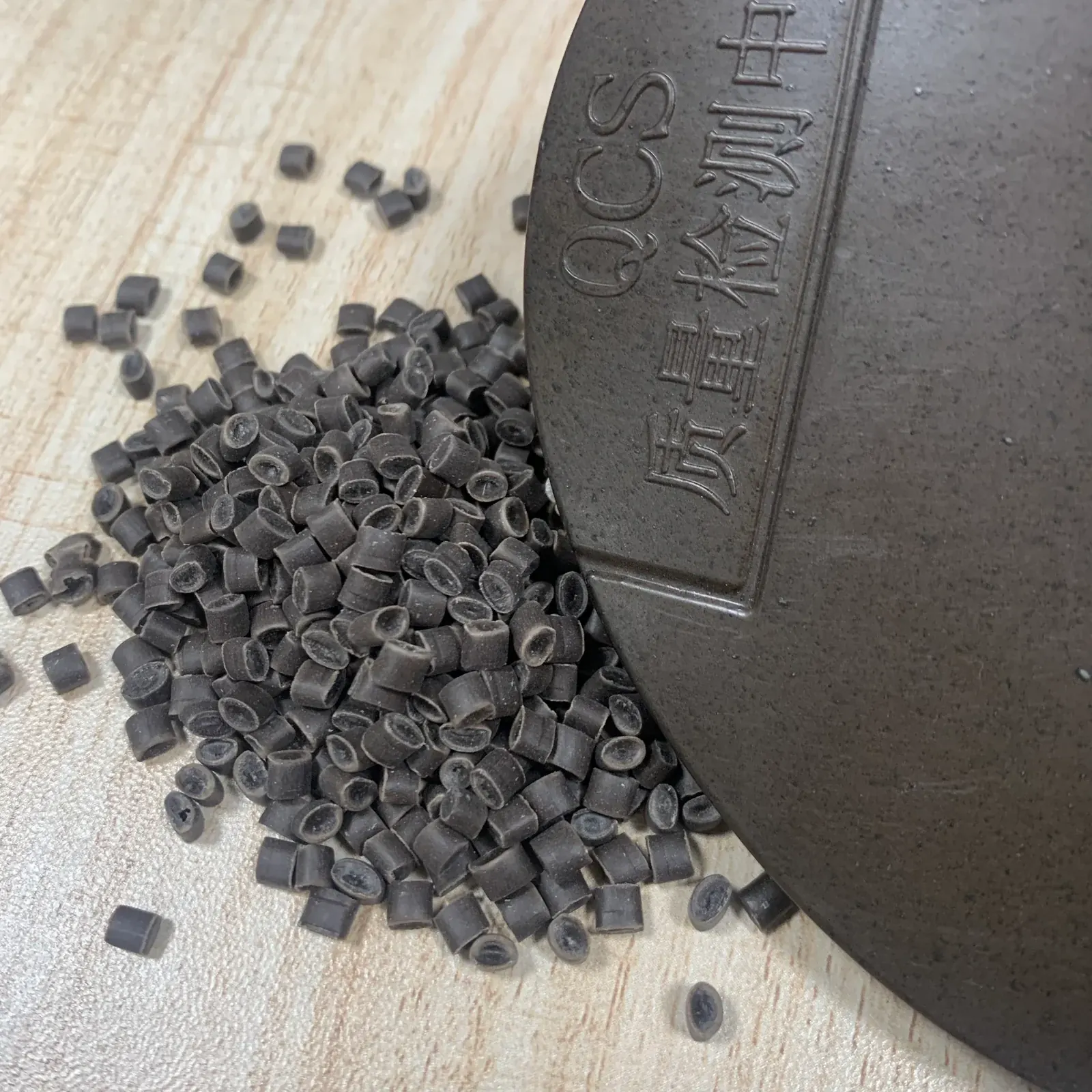 Coffee-ground PP pellets beside a dark coffee-brown molded sample plaque
